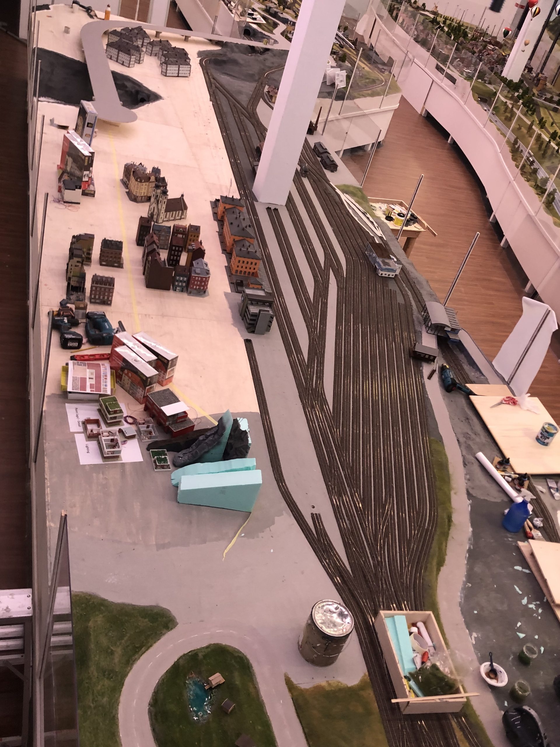 Construction of the Mega City section at Small Worlds Dubai, showing model train tracks, miniature buildings, and early-stage landscape design.