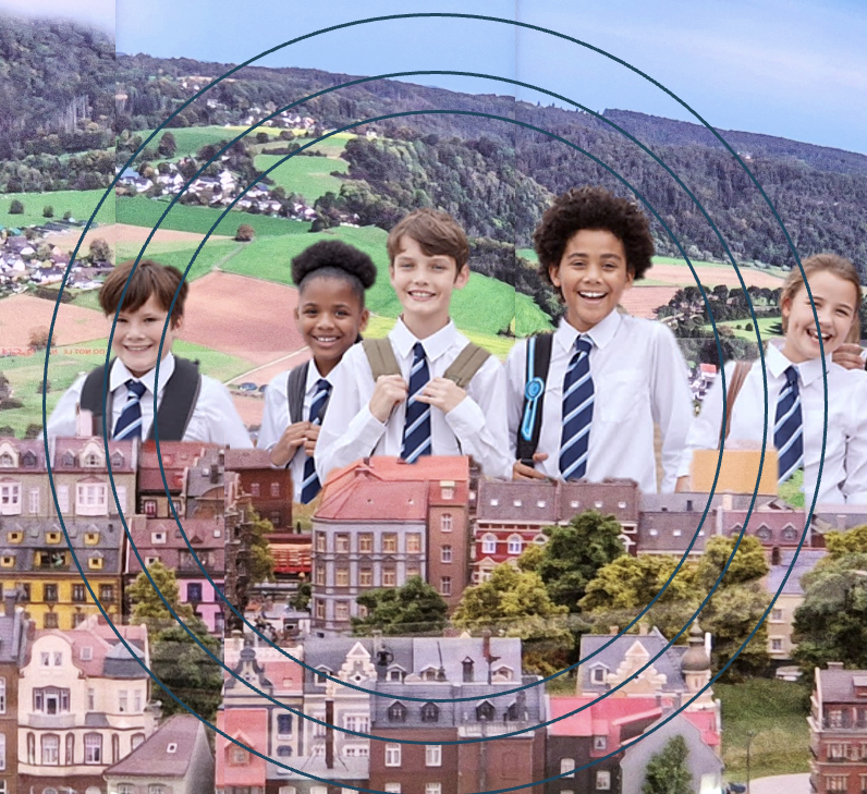 Group of school children in uniform smiling in front of a detailed miniature European city model at Small Worlds Dubai